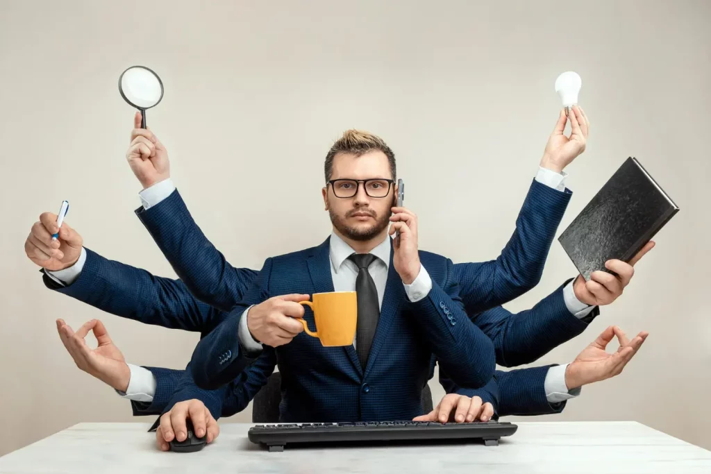 Imagem de um empresário realizando multitarefas, evidenciando a necessidade de aprender como sair da operação.